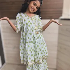 Fresh and breezy, this angarkha set features a lovely green leaf print on a white base. The gold trim and playful tassel make it a perfect outfit for any festive or casual occasion.