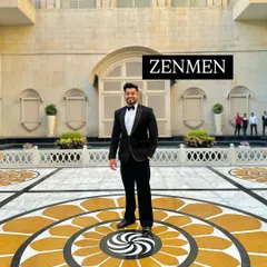 A full-length shot of me at an awards event, wearing a black tuxedo with abstract silver embroidery. The grand setting perfectly complements the sophisticated outfit.