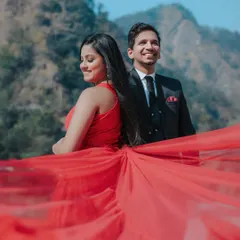 A dramatic shot with a flowing red gown against the mountainous backdrop of Rishikesh. Using props like long fabric trails adds a cinematic flair to outdoor shoots.