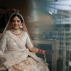 A candid shot of Kanika getting her final touches. The soft lighting highlights the clean, elegant lines of her makeup and the beautiful details of her bridal attire.