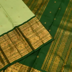 A close-up of the contrast between the light green body with gold buttas and the rich, dark green border.