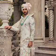 This sherwani tells a story of heritage with its pictorial embroidery, featuring motifs of royal gardens and peacocks. Paired with a soft pink turban and a layered emerald necklace, it is an ensemble crafted for a modern sovereign.