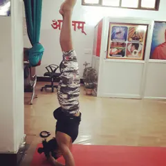 A student practices Pincha Mayurasana (Feathered Peacock Pose), an advanced inversion. Our training provides the skills and guidance to safely explore challenging asanas.