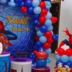 For superhero fans, I offer themes like this Spiderman setup. It includes a custom backdrop with the birthday boy's name and age, a red and blue balloon garland, and a Spiderman character prop.