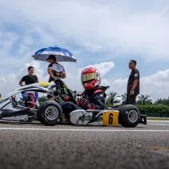 Our team provides shade for a driver on the grid, managing every detail to ensure they are comfortable and focused.