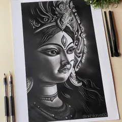 The divine feminine power of Maa Durga, captured in a striking charcoal drawing. The deep blacks and subtle highlights bring out her intense yet compassionate expression.