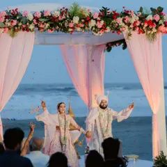 A fairytale wedding on the beaches of Goa. The pastel mandap, the ocean backdrop, and the celebrating couple create a perfect destination wedding memory.