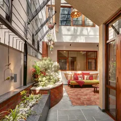 An internal courtyard that acts as the home's sanctum. The design uses brick planters, slate flooring, and open-to-sky elements to create a peaceful, green oasis that brings nature right into the heart of the house.