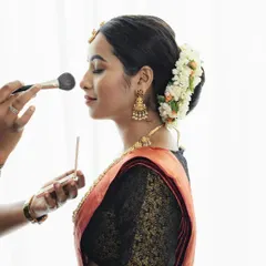Here is a glimpse of my process. I am applying a light dusting of powder to set the makeup, ensuring it lasts all day while maintaining a skin-like finish. This is a crucial step for a flawless, long-lasting traditional look.