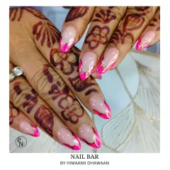 A vibrant and festive look. These nails feature a bright pink design with gold accents, perfectly matching the intricate mehendi for a celebratory feel.