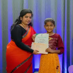A proud teacher presents a grade completion certificate to one of our young vocal students. We believe in celebrating every step of a student's musical journey.