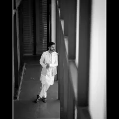 A timeless black and white portrait of the groom. The use of architectural lines and natural light creates a pensive and stylish shot.