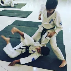 My self-defense seminars are designed to be practical for everyone. Here, two young students practice a takedown drill on a mat, learning how to control an opponent safely and effectively in a ground-based situation.