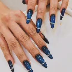 For those who love a dramatic flair, we created this stiletto nail set featuring a deep blue cat-eye effect. To elevate the look, we added a delicate band of shimmering rhinestones, making each nail a piece of jewelry.