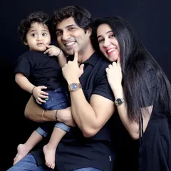 A modern and stylish studio family portrait against a simple black background. This classic setup puts all the focus on the family's connection and joyful expressions.