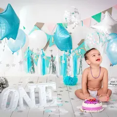 A first birthday cake smash is a milestone full of joy and wonder. I create these fun, celebratory setups in my studio, complete with balloons and props, to capture your baby's delightful reactions.