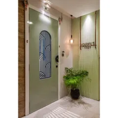 We designed this main entrance to be elegant and impressive. The sage green door features a custom reeded glass panel with an art-deco-inspired pattern, complemented by a fluted wall and a modern nameplate.