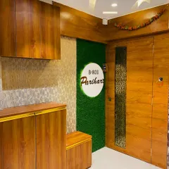 We designed this entrance for the Parihar family with a mix of textures. The design includes a main door with a jali insert, a shoe rack, and a green artificial grass panel for the nameplate.