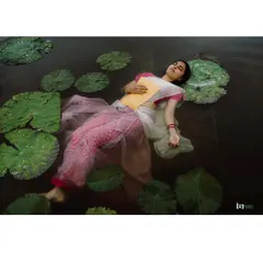 An artistic concept shoot inspired by Ophelia. The model floating in the water with lily pads creates a serene, painterly, and unforgettable image.