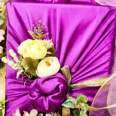 Furoshiki, the art of Japanese fabric wrapping, adds a unique and elegant touch to engagement gifts. Here, I've used a vibrant purple fabric with floral details to wrap boxes of nuts and sweets.