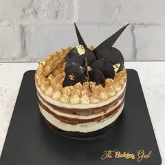A look at one of my recent custom cakes, a beautiful Tiramisu cake. It's decorated with gold leaf and chocolate shards for an elegant finish, perfect for a special celebration.