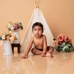A boho-themed baby photoshoot featuring a cute teepee and floral props. I provide various themes to make your baby's portraits unique and special.