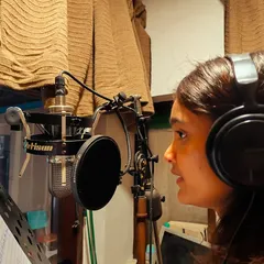 A profile shot of me completely focused during a vocal take. You can see the sheet music in front of me as I work on getting the pitch and emotion just right for the track.