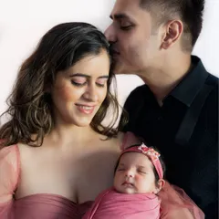 A father's gentle kiss for his newborn daughter. These are the moments that melt my heart. The family is dressed in soft, coordinating colors, creating a peaceful and loving portrait.
