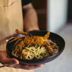 If pasta could talk, this one would tell you stories of long drives by the sea. Fresh linguine is tossed with roasted chilli and garlic olive oil, then crowned with a crispy soft-shell crab. It tastes like somewhere far away, yet deeply familiar.