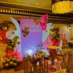 A whimsical butterfly-themed birthday for 'Avishi'. This setup combines gold and pink balloons, large butterfly cutouts, and a personalized backdrop for a sweet and stylish party.