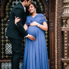 A loving couple's portrait taken against an ornate, traditional doorway. This type of location adds a touch of grandeur and architectural beauty to your outdoor maternity photos.