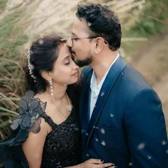 A romantic pre-wedding portrait. We captured this beautiful moment outdoors, with the groom kissing his bride-to-be's forehead amidst a natural, dreamy setting.