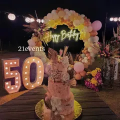 I also design elegant outdoor setups for milestone birthdays. This 50th birthday celebration featured a rustic boho theme with a balloon arch in warm tones, a 'Happy Birthday' neon sign, and large marquee numbers, creating a magical evening ambiance.