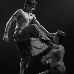 A black and white shot from 'ATAH' that captures a moment of tension and power. The physicality of the performance is central to its storytelling.