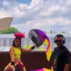 Posing with a fan dancer during a vibrant daytime event. Her performance added a beautiful, flowing visual element that perfectly complemented the sunny, upbeat music.
