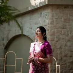 A serene bridal portrait captured in the warm sunlight. The bride, dressed in a beautiful traditional saree, takes a quiet moment to herself, her calm demeanor reflecting the significance of the day.