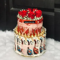 A unique alternative to a traditional birthday cake. This two-tiered chocolate tower is made from KitKats and Galaxy bars, topped with fresh roses for an elegant and delicious centerpiece.