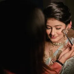 Applying a touch of blush to bring a warm, natural flush to the bride's cheeks for her engagement look.