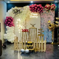 This wide shot displays the complete birthday arrangement with a balloon half-arch, shimmer wall, and decorative props. The combination of chrome and pastel balloons gives it a modern and elegant feel, suitable for any stylish birthday bash.