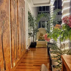 At night, our designs truly come to life. Here, custom-made corten steel panels with laser-cut designs are backlit for a dramatic effect, while uplighting on the bougainvillea and a gentle stone water feature create a warm and magical ambiance.