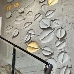 We believe stairways are an opportunity for art. This inspirational image shows a stunning mural of cascading leaves on a stone-clad wall, with select leaves finished in gold to catch the light. It's a perfect example of turning a transitional space into a feature.