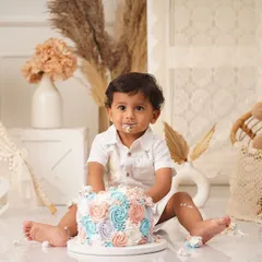This is what it's all about! A close-up of this cutie enjoying his colorful rosette smash cake.