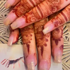 A subtle and shimmery set of nails that looks beautiful with bridal mehendi. The sheer, pearlescent polish adds a touch of elegance without overpowering the henna art.