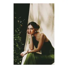 A quiet, contemplative portrait from the AVEKA campaign. The styling is classic and refined, focusing on the simple beauty of the dress and the serene expression of the model.