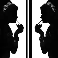 An artistic silhouette of the bride getting ready. This creative black and white shot focuses on her form and the act of preparation.