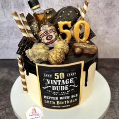For the "Vintage Dude" turning 50, this cake was all about indulgence. It's a rich chocolate cake loaded with more chocolates, wafers, and gold accents, topped with a miniature Chivas Regal bottle to celebrate a milestone in style.