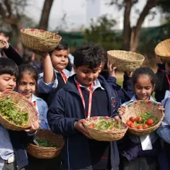Proud students showing off the fresh tomatoes and greens they harvested during their school trip. It's a rewarding experience that connects them directly to agriculture.