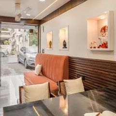 From this angle, you can see the custom display niches for decor and the large glass door that brings in natural light. The layout is designed for a smooth client flow and a welcoming atmosphere, even in a narrow space.