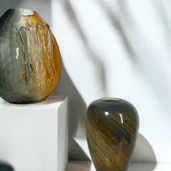 Earthy tones and fluid textures. This image pairs two of my blown glass vases, one with a dramatic, tactile surface and the other with elegant swirls, showcasing their complementary nature.