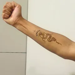 The dragon henna tattoo shown on the full forearm. It's a bold and modern choice.